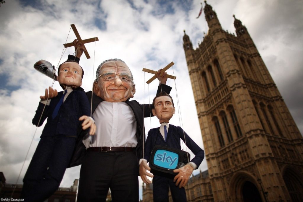 Protesters make their views of Rupert Murdoch plain during the debate on phone-hacking yesterday.