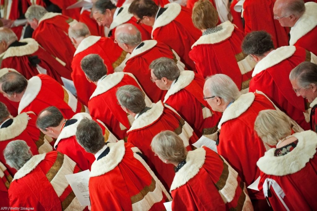 Members of the Lords, their existence threatened by this Queen's Speech, watch the monarch deliver her address to parliament