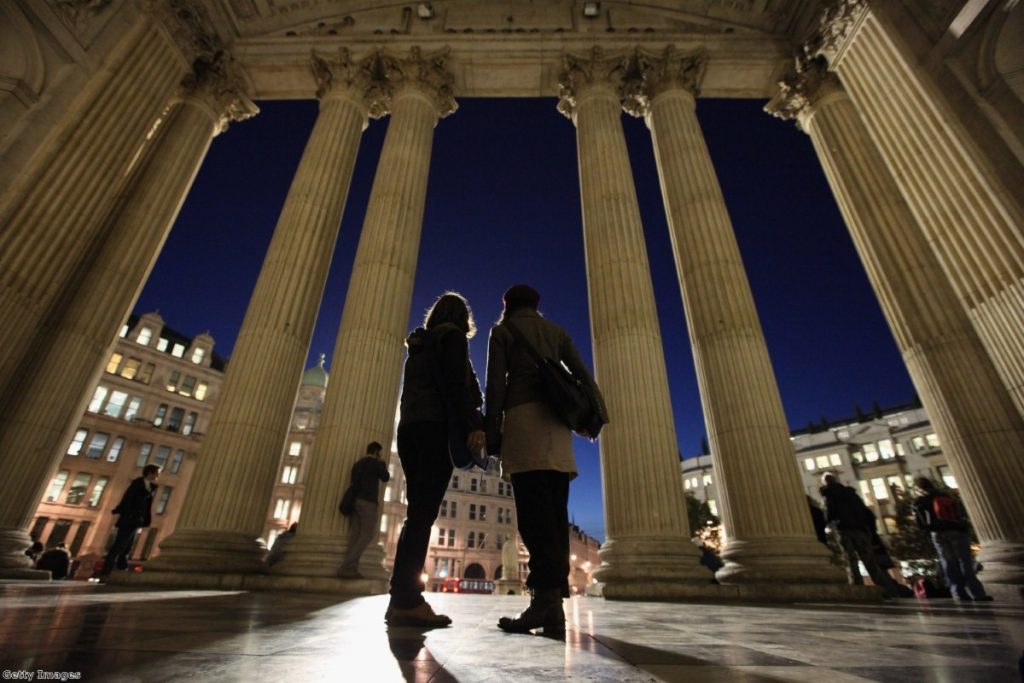 Tourists look out from St Pauls as the camp around the cathedral is spared eviction