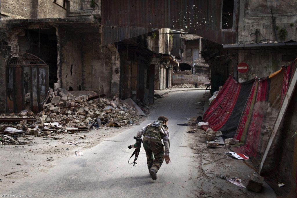 Syria: A rebel fighter tries to avoid sniper fire in Aleppo earlier this year. The debate on whether to supply rebel forces with weapons is unlikely to die down.