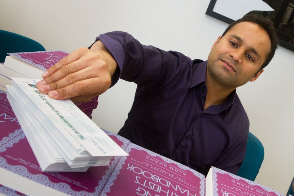 Alom Shaha with copies of his book before the launch