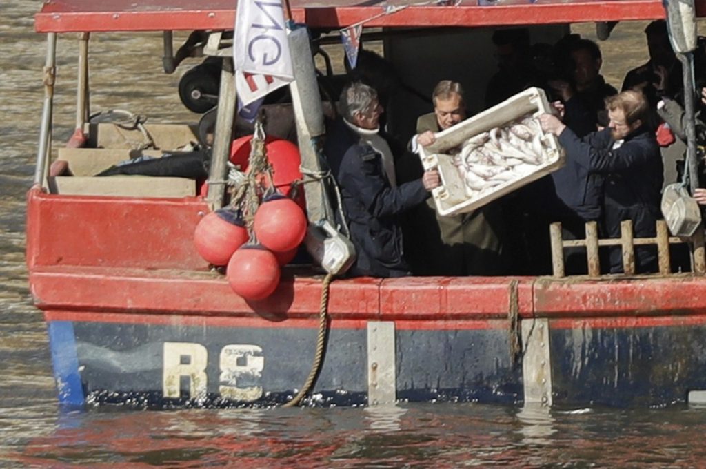 Nigel Farage helps tip a container of fish into the Thames on Wednesday in a protest stunt over the transition deal 