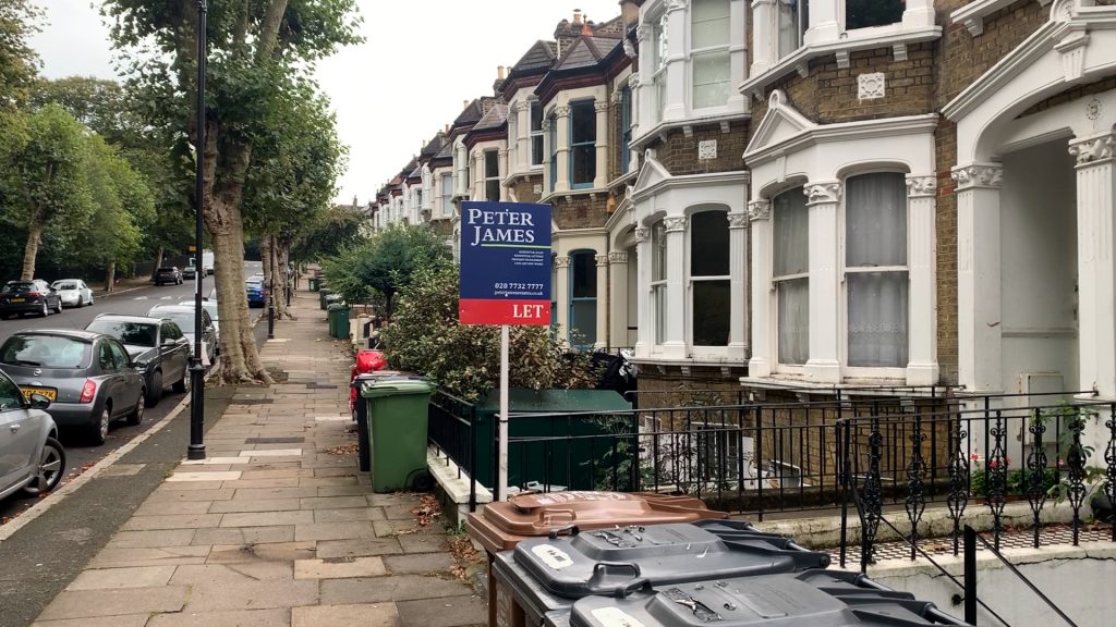 A to-let sign in front of some terraced houses