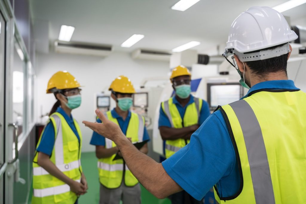 Factory workers meeting before work And put on a mask